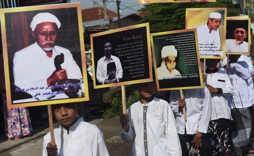 Santri membawa poster bergambar tokoh NU saat pawai Hari Santri Nasional di Kecamatan Diwek, Kabupaten Jombang, Jawa Timur, Sabtu (22/10/2022). 