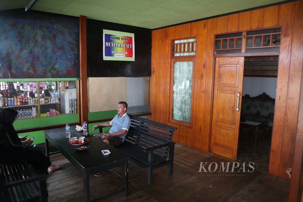 Pengunjung bersantai di teras rumah warga yang menjadi <i>homestay </i>di Desa Torosiaje, Kabupaten Pohuwato, Gorontalo, Jumat (15/7/2022).