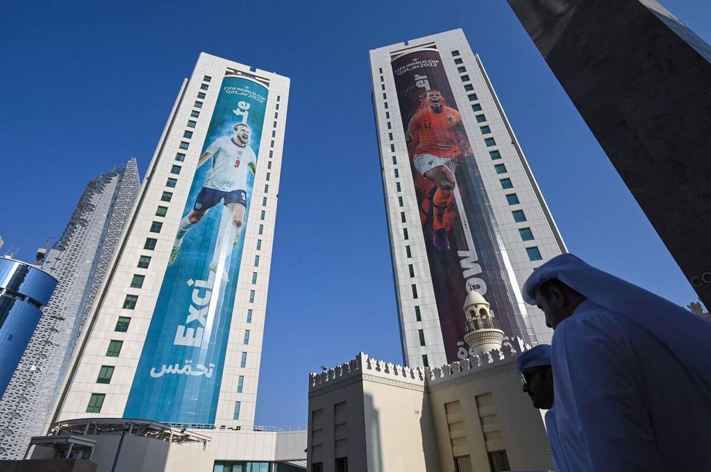 Spanduk raksasa bergambar kapten tim nasional Inggris Harry Kane (kiri) digantung di sebuah bangunan di Doha, Qatar, 23 Oktober 2022. Pemasangan spanduk raksasa merupakan salah satu upaya promosi Piala Dunia Qatar.
