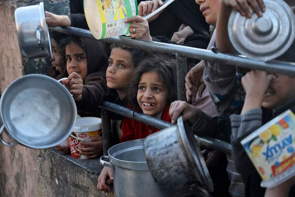 Para pengungsi menunggu pembagian jatah makanan yang diberikan lembaga amal sebelum buka puasa pada hari pertama Ramadhan di Rafah, Jalur Gaza selatan, Senin (11/3/2024). 