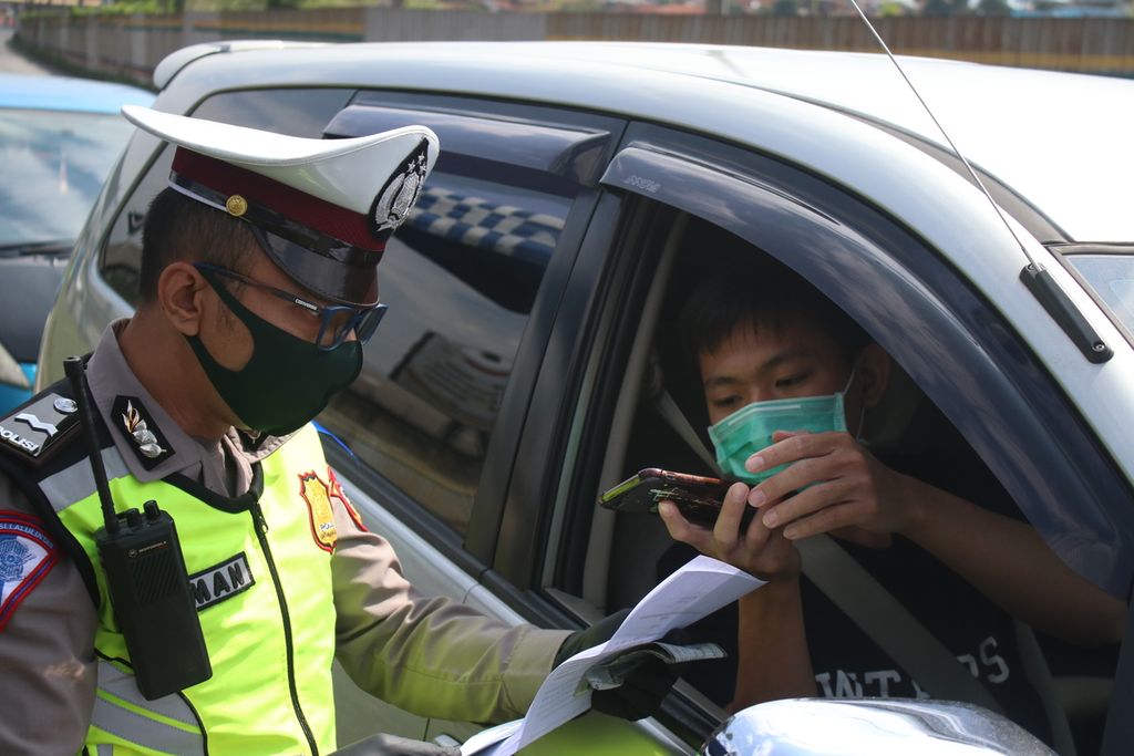 Petugas memeriksa surat jalan pengendara di akses keluar Tol Cileunyi, Kabupaten Bandung, Jumat (24/4/2020). Pascapelarangan mudik oleh pemerintah, kendaraan yang melintasi Jalur Tol Cileunyi tanpa ada kepentingan khusus diminta memutar balik.