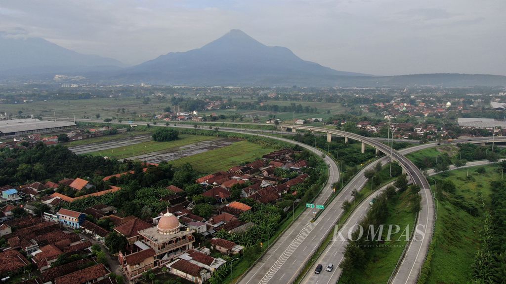 Lanekap Tol Gempol-Pandaan di simpang susun Gempol (Gempol Juction) di sekitar Km 775, Pasuruan, Jawa Timur, dengan latar belakang Gunung Penanggungan (kanan) dan Gunung Arjuna, Rabu (15/4/2021). 