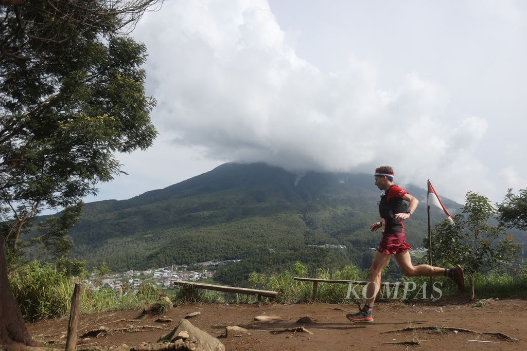 Pelari menuruni Bukit Mongkrang dengan latar belakang Gunung Lawu dalam perlombaan Siksorogo Lawu Ultra (SLU) 2023 di kawasan Tawangmangu, Karanganyar, Jawa Tengah, Sabtu (2/12/2023).