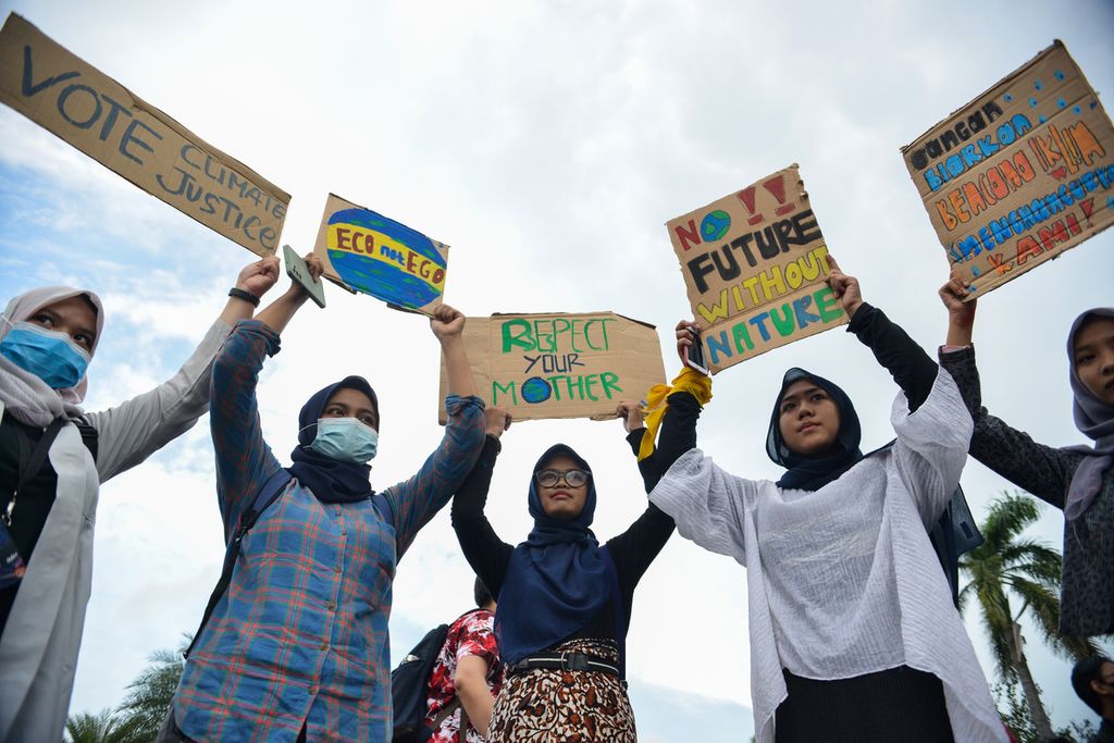 Sejumlah massa aksi membentangkan spanduk berisikan ancaman krisis iklim di kawasan Patung Kuda Arjuna Wiwaha, Jakarta, Jumat (3/3/2023). 