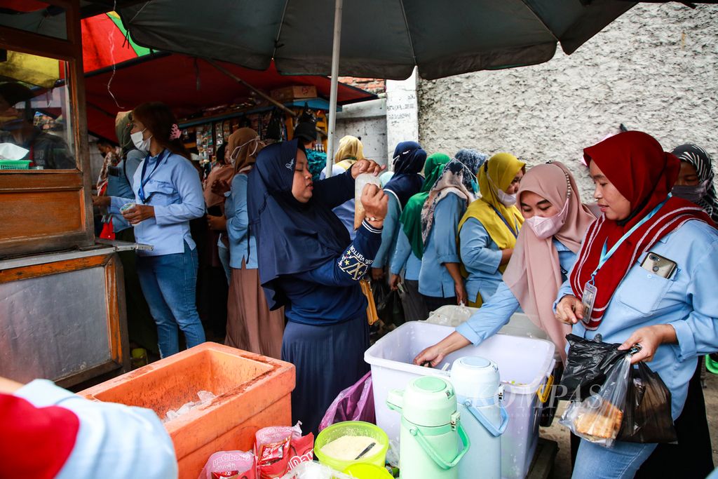 Footwear factory workers shop for lunch from street vendors outside the factory in the Gerendeng area, Karawaci, Tangerang City, Banten, Monday (11/14/2022). Layoffs are currently hitting a number of labor-intensive industries, such as textiles and textile products or TPT and footwear products.