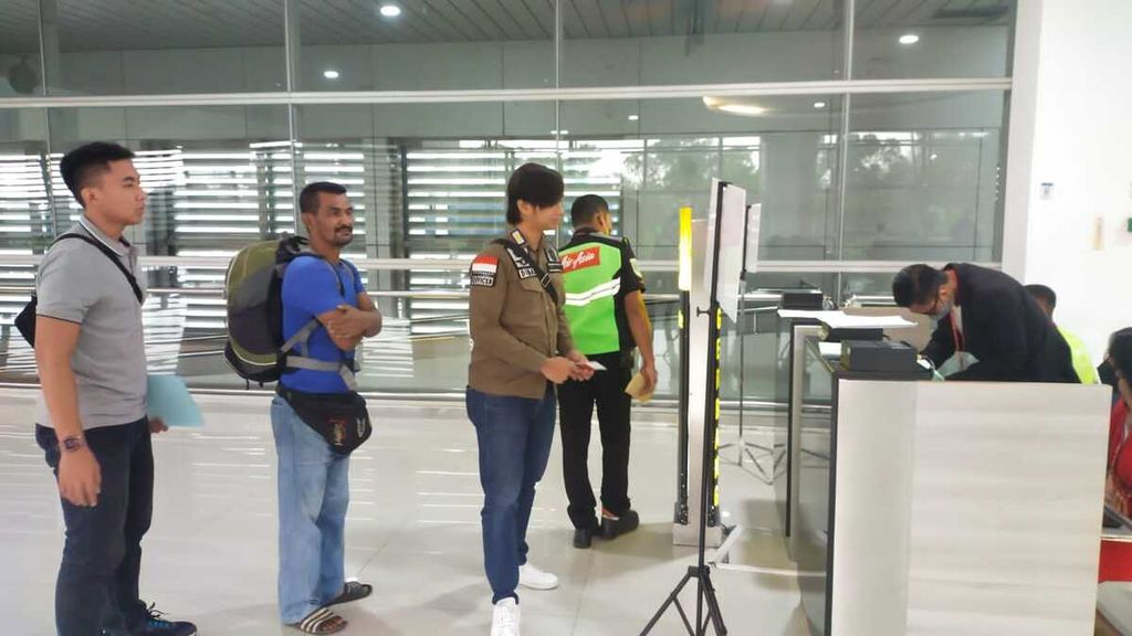 Warga negara Malaysia berinisial HBR (berbaju biru) saat proses deportasi di Bandara Internasional Juanda, Surabaya, Jawa Timur, Sabtu (8/7/2023). HBR dipulangkan ke negaranya karena menyalahi izin tinggal dan meresahkan masyarakat.