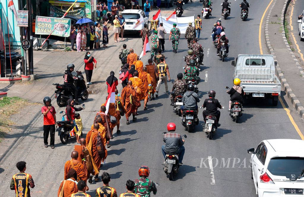 Iring-iringan 33 biksu yang berjalan kaki ribuan kilometer sebagai bagian dari ritual <i>thudong </i>menuju Borobudur saat melintasi jalur pantura di Kecamatan Tugu, Kota Semarang, Jawa Tengah, Minggu (28/5/2023). 