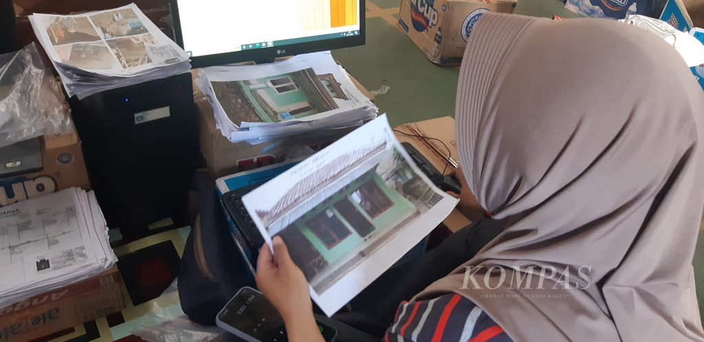Petugas mencermati bukti foto penilaian kondisi rumah warga yang rusak akibat gempa di Desa Sukawangi, Kecamatan Warungkondang Kabupaten Cianjur, Jawa Barat, Selasa (29/11/2022).