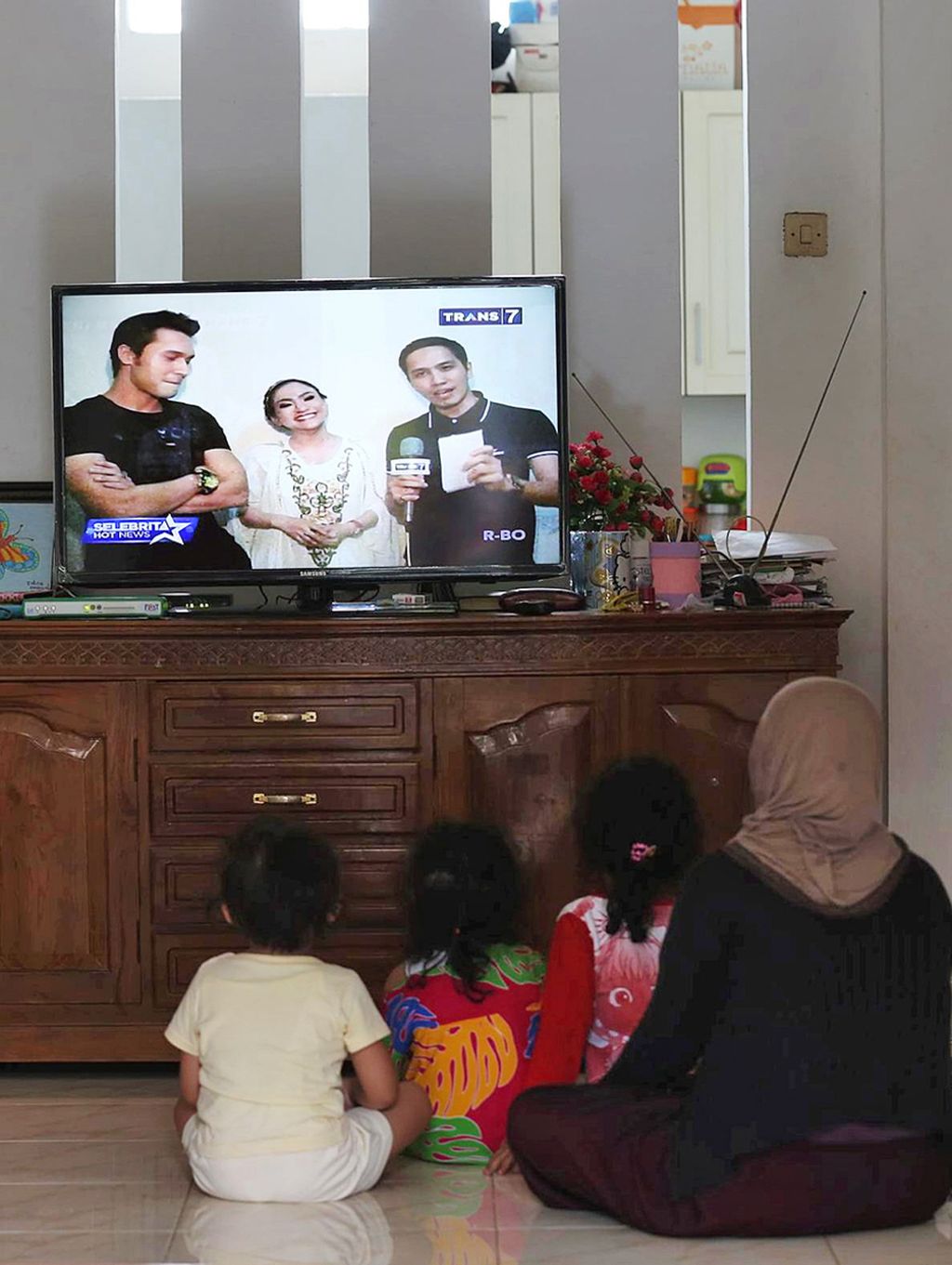 Warga menonton tayangan televisi di rumahnya di Pondok Karya, Tangerang Selatan, Selasa (23/6/2015). Duduk menonton televisi dalam waktu lama setiap hari berpotensi memicu berbagai masalah kesehatan.