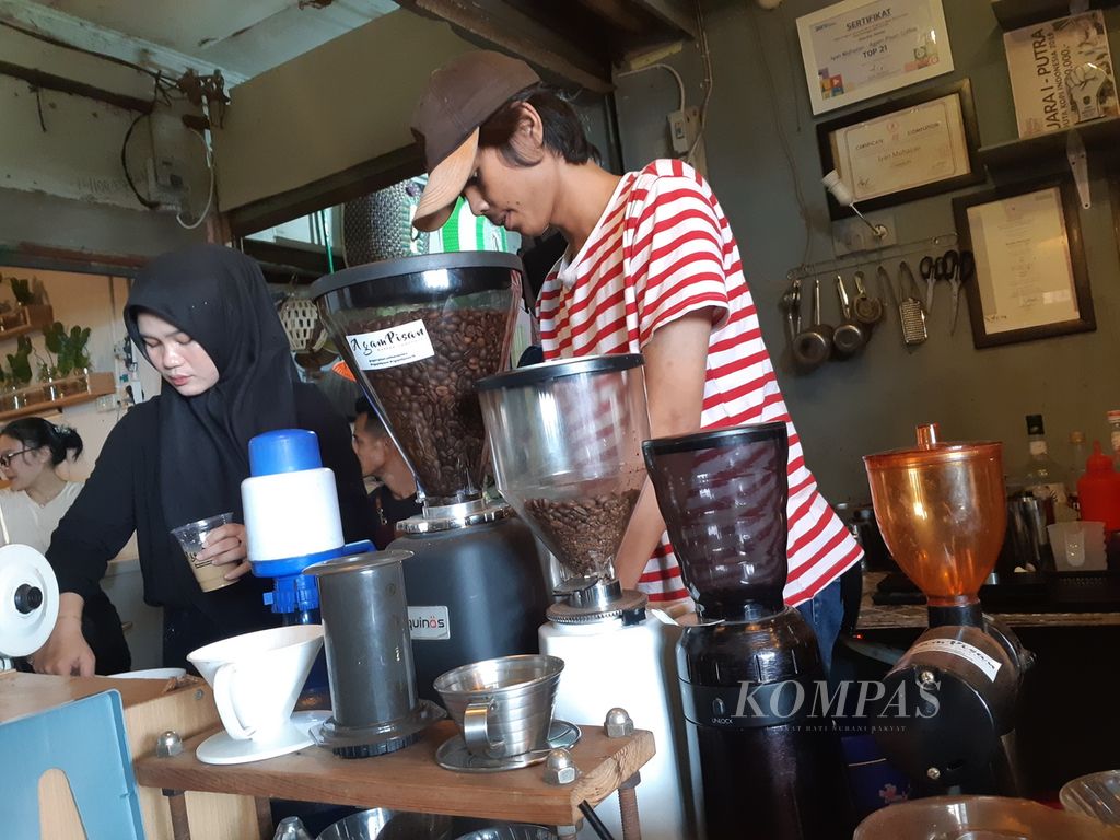 Seorang barista sedang meracik kopi di Kedai Agam Pisan di lantai tiga Pasar 16 Ilir, Palembang, Sumatera Selatan, Rabu (14/6/2023). Keberadaan kedai ini menambah minat warga untuk berwisata di pinggiran Sungai Musi.