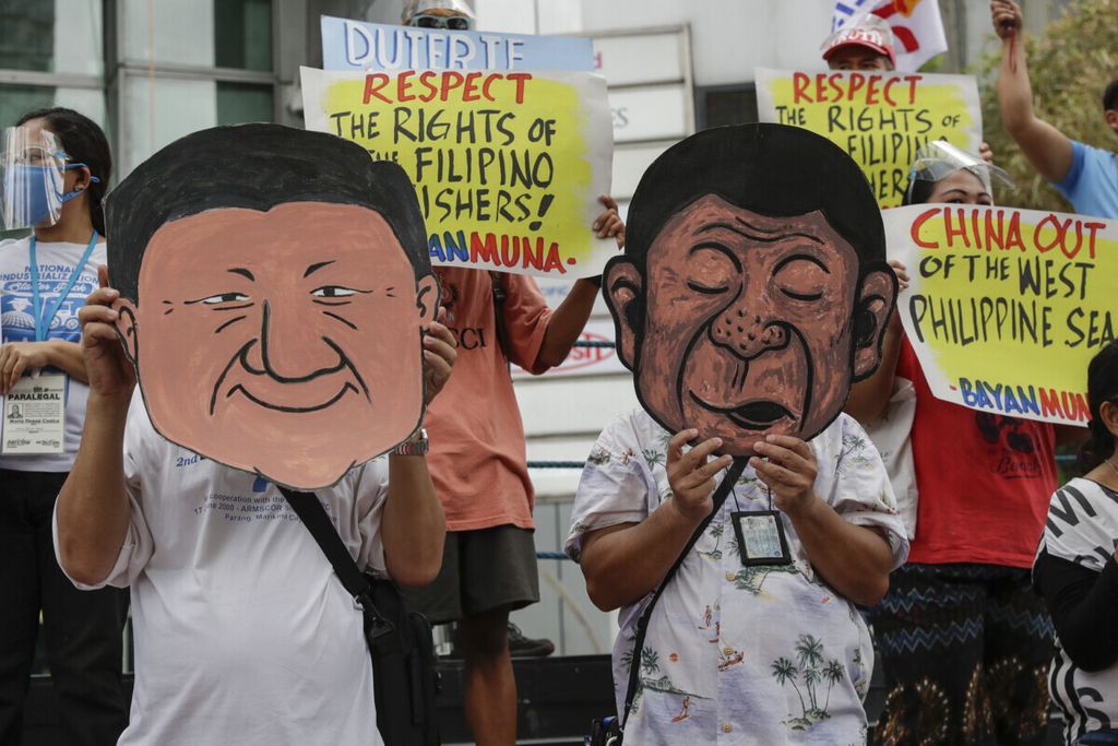 Para pengunjuk rasa mengenakan topeng Presiden Filipina Rodrigo Duterte dan Presiden China Xi Jinping saat berunjukrasa di luar konsulat China di Metro Manila, Filipina, Jumat (7/5/2021). Kelompok itu menuntut China keluar dari wilayah yang diklaim Filipina di Laut Cina Selatan. (AP/Aaron Favila)
