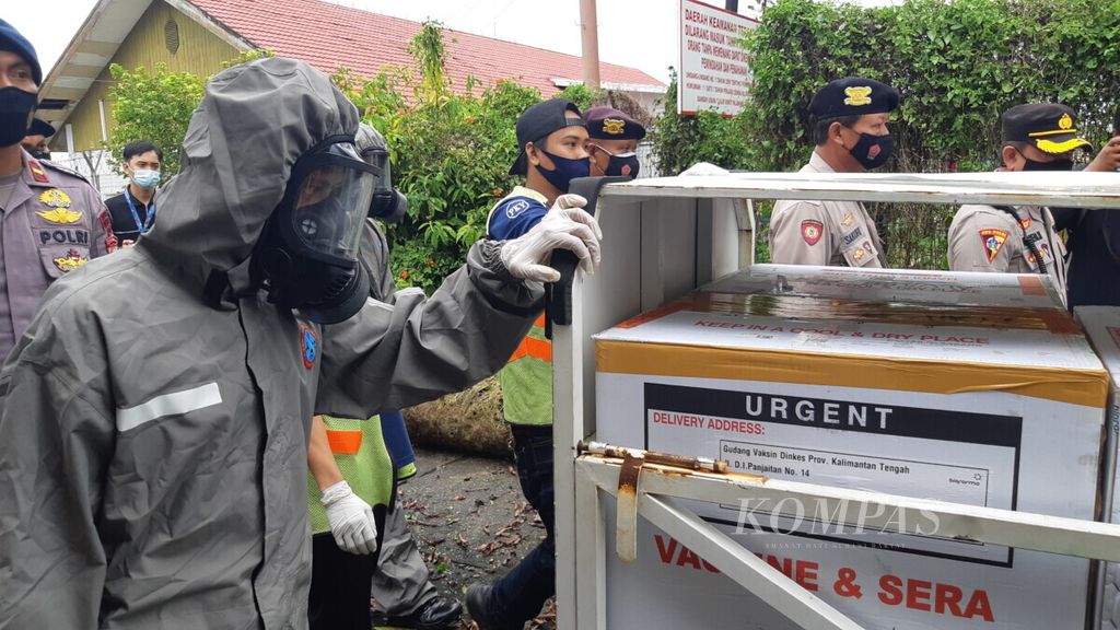 Petugas membawa vaksin dari pesawat menuju truk milik Dinas Kesehatan Provinsi Kalimantan Tengah, Selasa (5/1/2021).