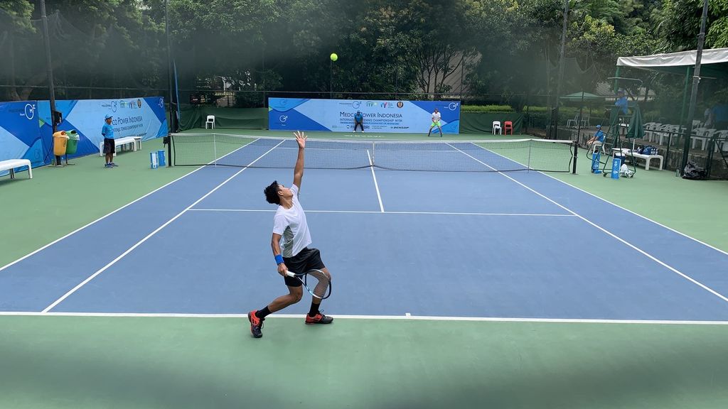 Petenis Indonesia M Rifqi Fitriadi melakukan servis saat melawan petenis Rumania, Nicholas David Ionel, pada babak perempat final seri kedua turnamen Medco Power Tennis Champinships M15 2023 di lapangan tenis Hotel Sultan, Jumat (27/1/2023). 