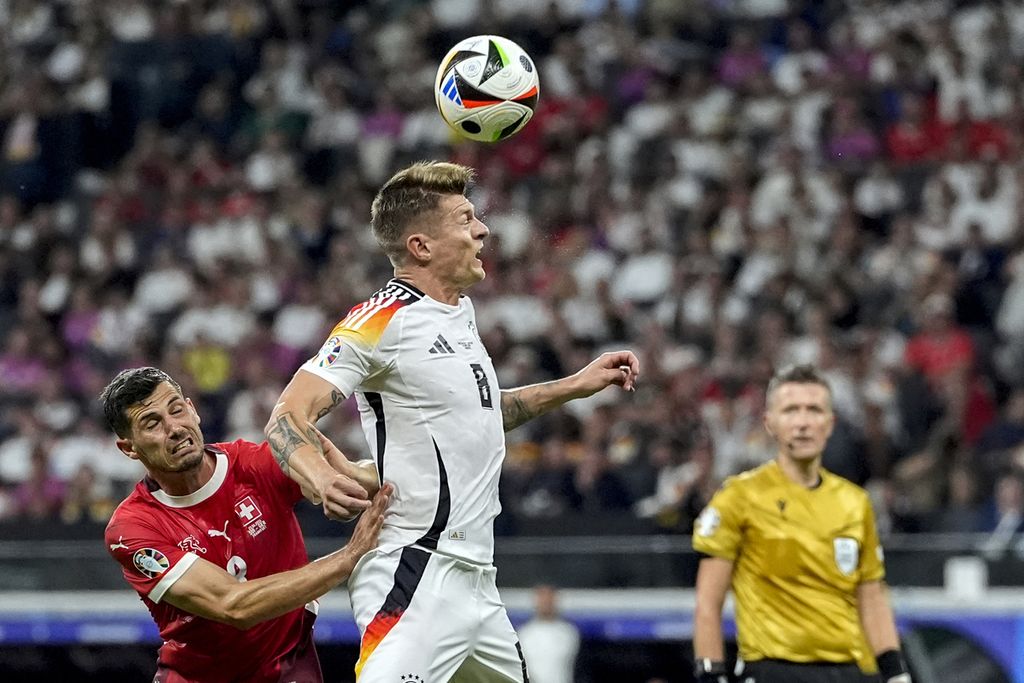 Pemain Jerman, Toni Kroos, menyundul bola dalam pertandingan Grup A Piala Eropa antara Swiss dan Jerman di Frankfurt, Senin (24/6/2024) dini hari WIB. Jerman dan Swiss lolos ke babak 16 besar setelah laga tersebut berakhir imbang, 1-1.