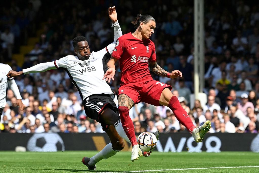 Penyerang Liverpool, Darwin Nunez (kanan), dibayangi bek Fulham Tosin Adarabioyo, dalam pertandingan Liga Inggris antara Fulham dan Liverpool di Stadion Craven Cottage, Fulham, Sabtu (6/8/2022). Pertandingan berakhir imbang, 2-2. 