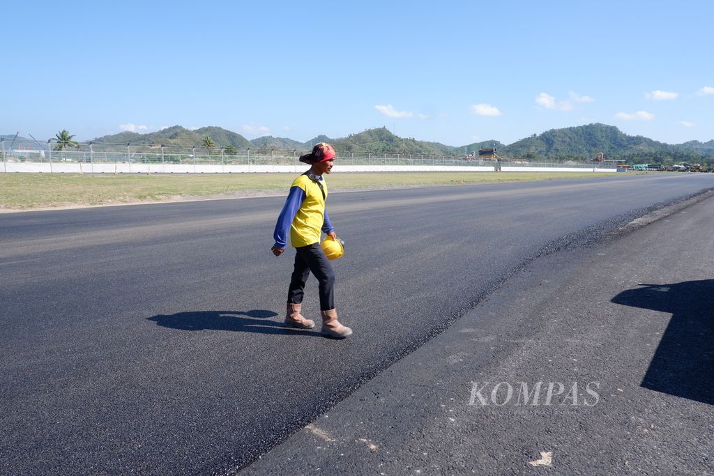 Seorang pekerja berjalan melewati lintasan utama Sirkuit Mandalika di Kuta, Pujut, Lombok Tengah, NTB, Minggu (15/8/2021). Pekerjaan pengaspalan lintasan utama sirkuit tersebut telah selesai dilakukan.