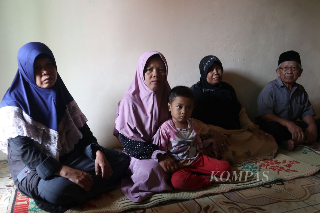 Carmi (kiri), mantan pekerja migran Indonesia, berfoto bersama keluarganya di Desa Rawaurip, Kecamatan Pangenan, Kabupaten Cirebon, Jawa Barat, Jumat (5/2/2021).