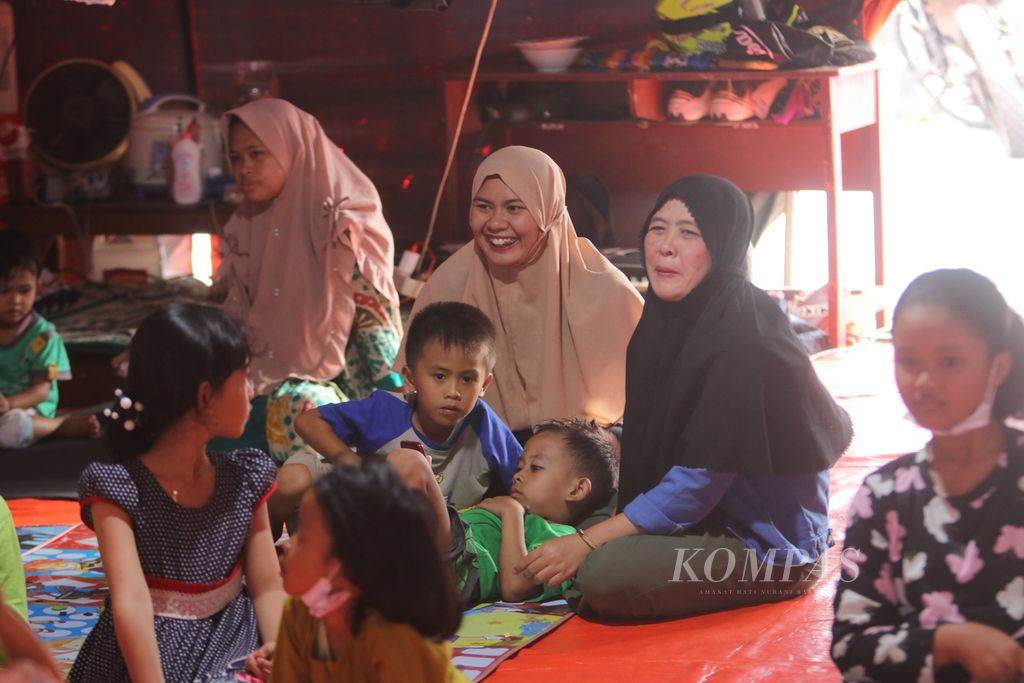 Beberapa orangtua turut tertawa saat melihat anaknya bercanda di sela-sela belajar bersama di tenda darurat BNPB yang didirikan di SDN Jambudipa 2, Kecamatan Warungkondang, Kabupaten Cianjur, Jawa Barat, Sabtu (17/12/2022). Anak-anak ini mendapatkan pemahaman terkait stres yang menimpa mereka saat gempa terjadi.