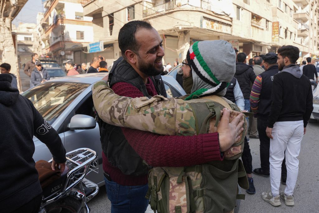 Orang-orang merayakan kembalinya pejuang antipemerintah dan keluarga mereka dari pengasingan di Provinsi Idlib setibanya di Daraya, pinggiran Damaskus, Suriah, Senin (9/12/2024). Pemberontakan yang dipimpin oleh kelompok oposisi di Suriah berhasil merebut Damaskus lewat serangan kilat yang dilakukan sehari sebelumnya. 