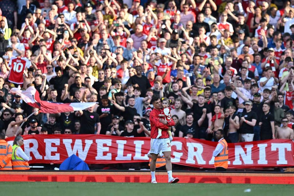 Suporter Arsenal membentangkan spanduk bertuliskan "Selamat Berpisah Granit" saat gelandang Arsenal, Granit Xhaka, berjalan di lapangan usai laga pekan terakhir Liga Inggris antara Arsenal dan Wolverhampton Wanderers di Stadion Emirates, London, Minggu (28/5/2023). 