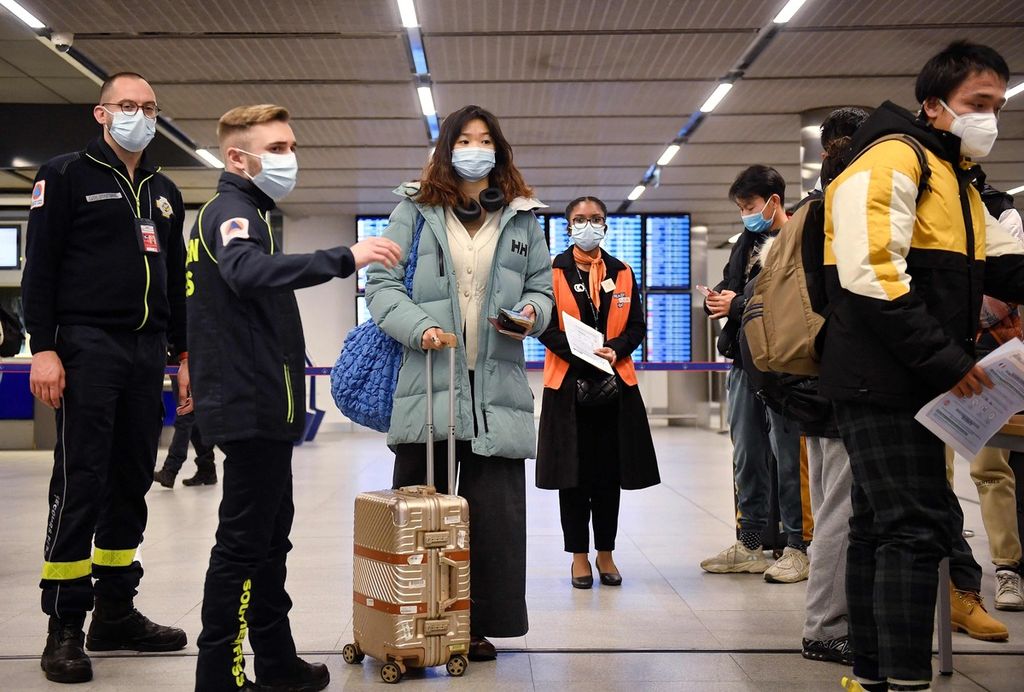 Penumpang pesawat terbang dari China menunggu pemeriksaan dokumen vaksin Covid-19 sebagai langkah preventif untuk mencegah penularan Covid-19 saat tiba di Bandara Paris-Charles de Gaulle, di Roissy, Perancis,  Minggu (1/1/2023). Perancis dan Inggris memeriksa ketat para pelaku perjalanan dari China.