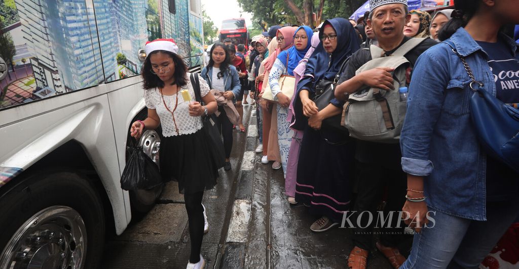 Warga mengantre untuk naik bus tingkat gratis Transjakarta di Halte Istiqlal, Jakarta Pusat, Rabu (25/12/2019). 