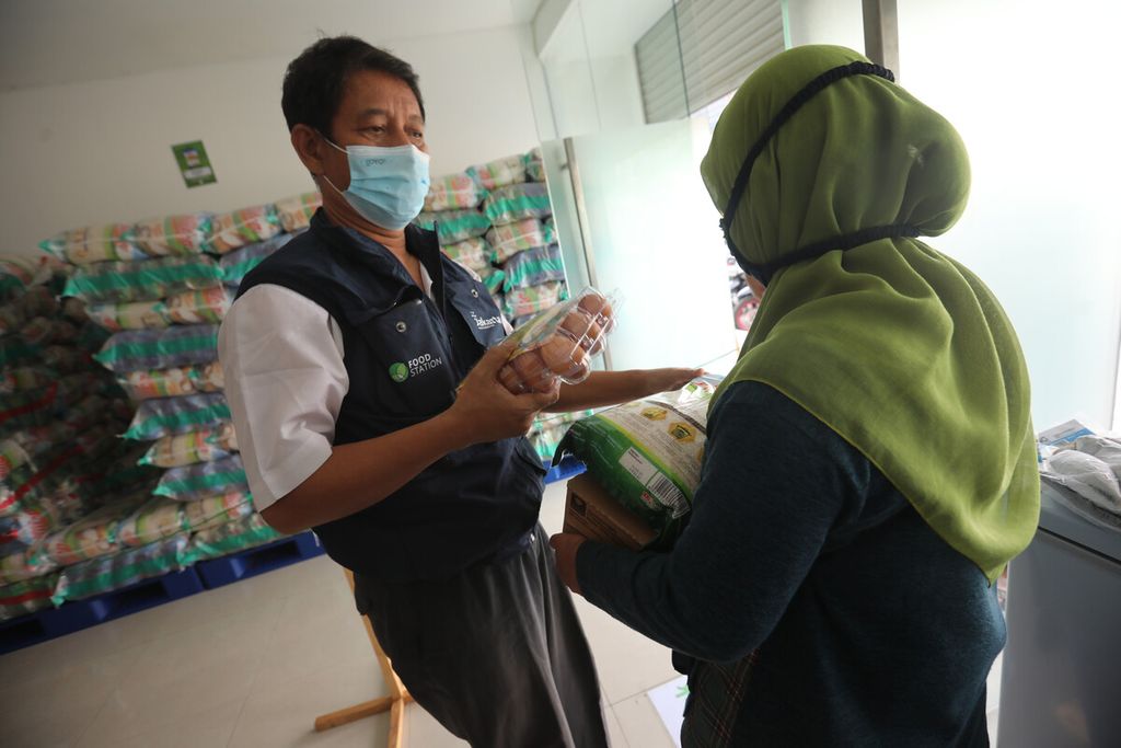 Petugas melayani warga penerima manfaat Program Pangan Bersubsidi yang berbelanja bahan makanan dengan Kartu Jakarta Pintar (KJP) di lokasi distribusi <i>food station</i> di Pasar Induk Beras Cipinang, Jakarta Timur, Senin (6/9/2021). 