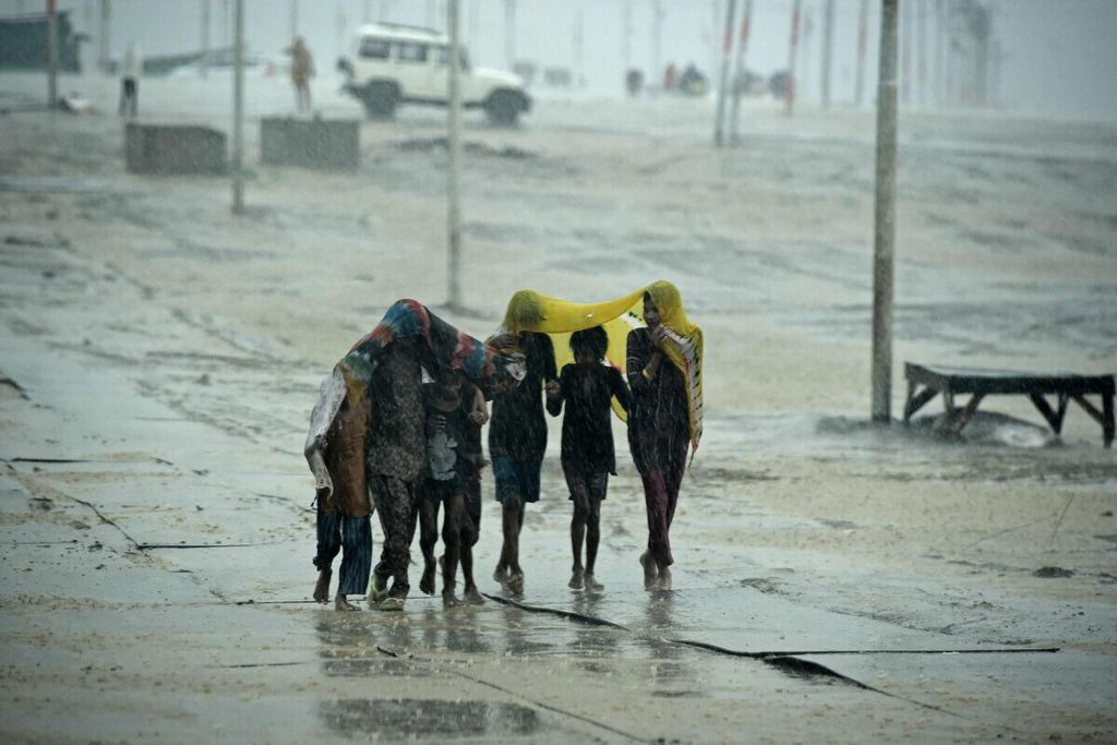 Anak-anak di Allahabad, India, berlindung dari hujan, 19 Mei 2021.