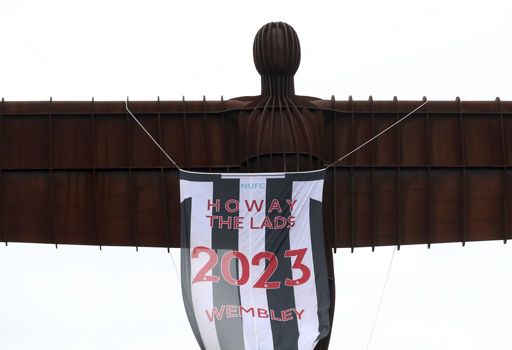 Patung Angel of The North di Gateshead, Inggris, digantungi spanduk berisi dukungan kepada tim Newcastle United, Sabtu (25/2/2023). Manchester United dan Newcastle United akan berhadapan dalam laga final Piala Liga Inggris di Stadion Wembley, London, Minggu (26/2/2023). 