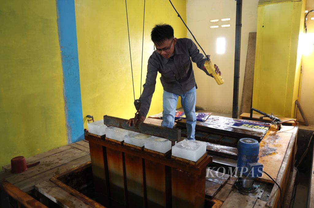 Jois Harsa mengeluarkan balok es dari cetakannya di Pabrik Es Bumdes Motekar, Desa Samudera Jaya, Kecamatan Caringin, Kabupaten Garut, Jawa Barat, Kamis (25/5/2023). Saat nelayan panen ikan, sekitar 60 balok es yang diproduksi pabrik ini terjual dalam satu hari. Harga jual balok es tersebut adalah Rp 25.000 per balok. 