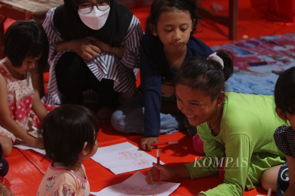 Sejumlah anak menggambar sambil bercanda saat belajar bersama di tenda darurat BNPB yang didirikan di SDN Jambudipa 2, Kecamatan Warungkondang, Kabupaten Cianjur, Jawa Barat, Sabtu (17/12/2022). Anak-anak ini mendapatkan pemahaman terkait stres yang menimpa mereka saat gempa terjadi.