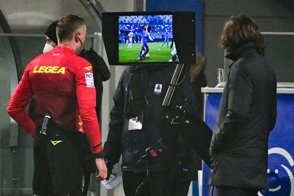 Wasit Paolo Valeri (kiri) memeriksa asisten wasit video (VAR) di samping Pelatih Juventus Andrea Pirlo (kanan) sebelum memberikan penalti kepada Napoli dalam pertandingan Piala Super Italia antara Juventus dan Napoli di Stadion Mapei.
