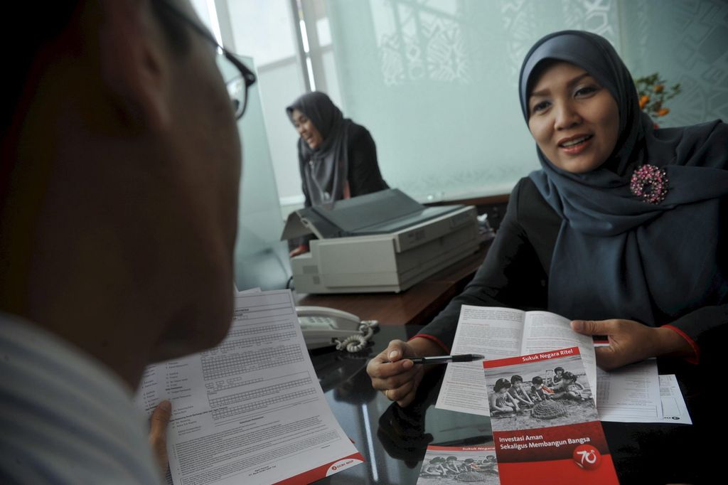 Petugas bank menjelaskan Sukuk Negara Ritel seri SR-003 yang mulai ditawarkan di Bank OCBC NISP, Jakarta, Februari 2011. 