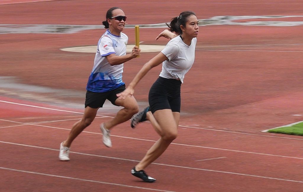 Pelari putri pelatnas asal Sulawesi Utara, Valentine Vanesa Lonteng, berusaha memberikan tongkat estafet kepada pelari asal DKI Jakarta, Jeany Nuraini, dalam latihan estafet 4 x 100 meter pelatnas sprint Pengurus Besar Persatuan Atletik Seluruh Indonesia di Stadion Madya Senayan, Jakarta, Selasa (15/3/2022). 