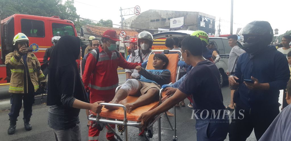 Seorang pemuda dievakuasi karena mengalami luka bakar akibat kebakaran di pinggir Jalan Raya Bogor Km 21 di Kelurahan Kampung Rambutan, Kecamatan Ciracas, Jakarta Timur, Minggu (25/12/2022) siang.