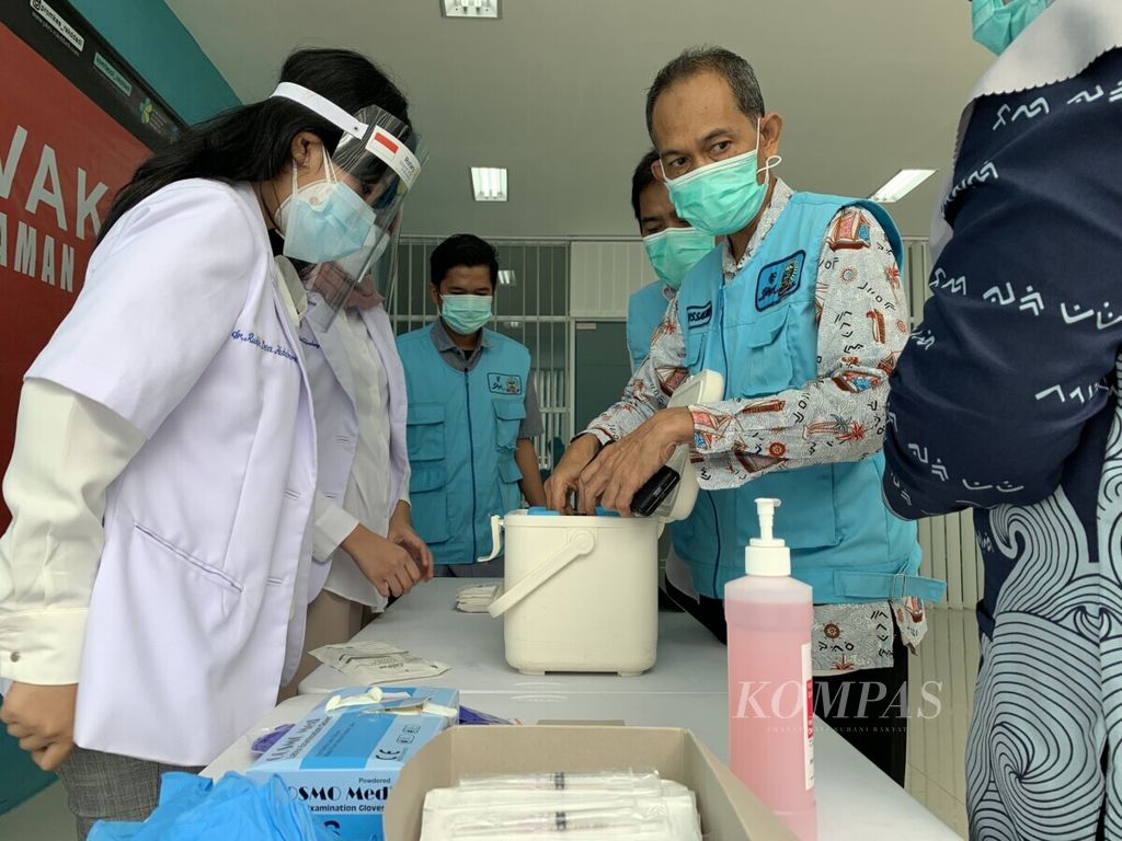 Petugas mengeluarkan vaksin Covid-19 dari kotak penyimpanan saat akan dilakukan vaksinasi pertama di Makassar, Sulsel, Kamis (14/1/2021).