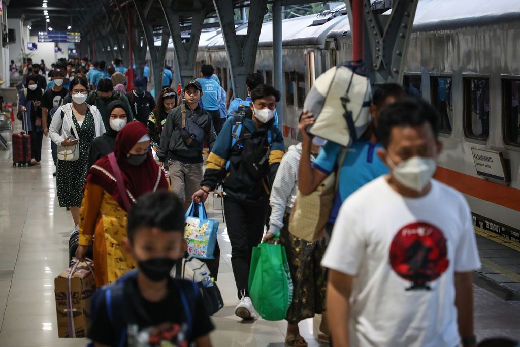 Para penumpang kereta api Bangunkarta berjalan menuju pintu keluar Stasiun Pasar Senen, Jakarta, Minggu (30/4/2023).