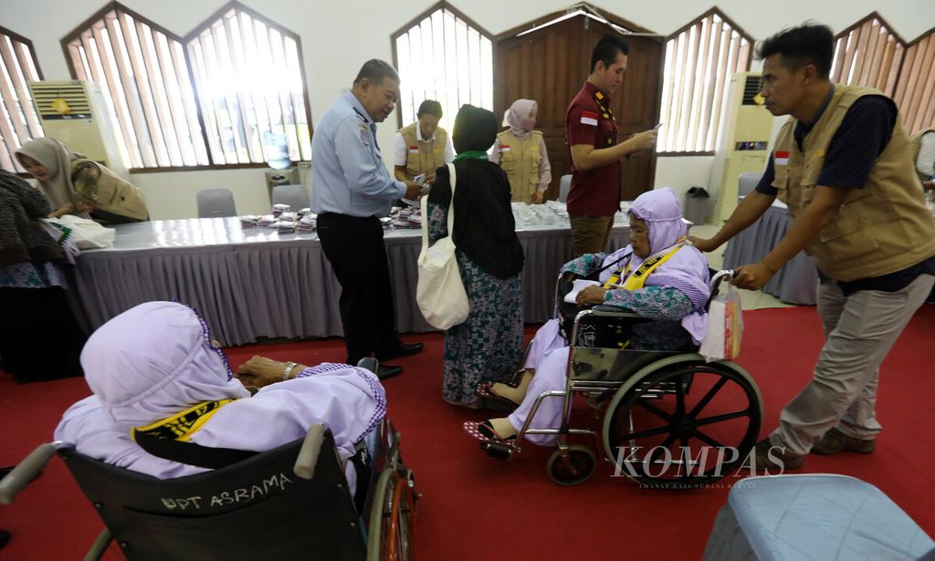 Petugas membantu calon jemaah haji lansia yang menggunakan kursi roda saat mengikuti persiapan di Asrama Haji Pondok Gede, Jakarta, Selasa (23/5/2023). 