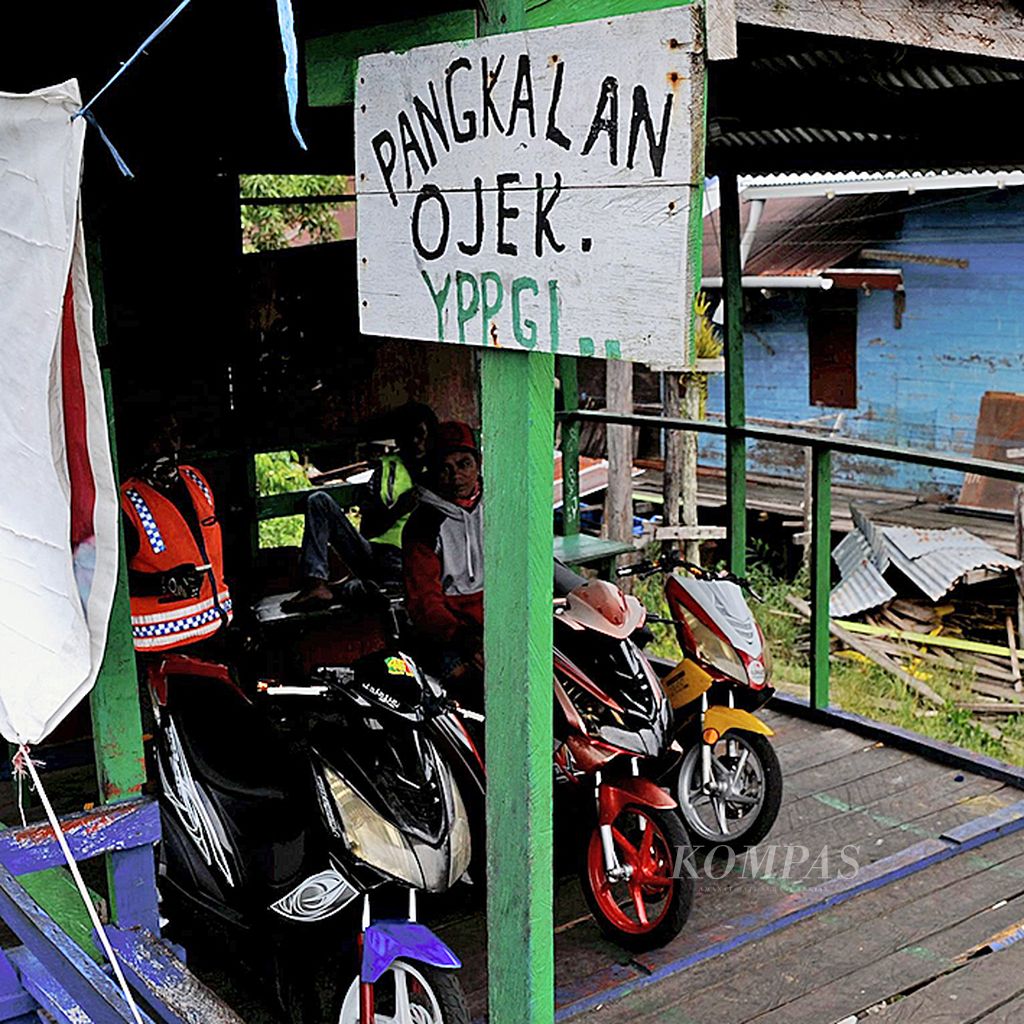 Pangkalan ojek motor listrik di Distrik Agats, Kabupaten Asmat, Papua, Jumat (26/1). Para pengojek memasang tarif Rp 20.000 sekali pengantaran menggunakan motor listrik yang menjadi transportasi utama di Distrik Agats.