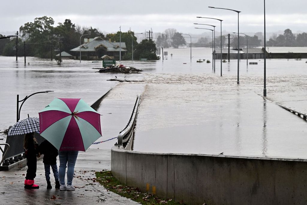 Penduduk melihat gedung-gedung dan jalanan di dekat Windsor Bridge yang terendam banjir akibat luapan Sungai Hawkesbury di Windsor, sebelah barat laut Sydney, 4 Juli 2022. 
