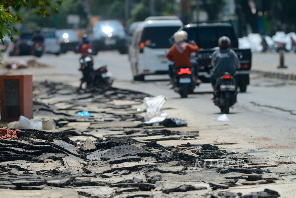 Lapisan aspal yang mengelupas setelah terendam dan terkena arus dari banjir yang merendam jalur pantura Demak-Kudus di Kecamatan Karanganyar, Kabupaten Demak, Jawa Tengah, Minggu (24/3/2024).