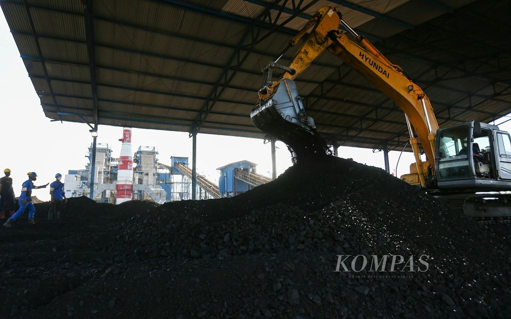 Eskavator mencampur sampah biomassa berupa cangkang kemiri dengan batubara di pembangkit listrik tenaga uap (PLTU) Ropa di Desa Keliwumbu, Kecamatan Mourole, Kabupaten Ende, Nusa Tenggara Timur, Kamis (7/10/2021).