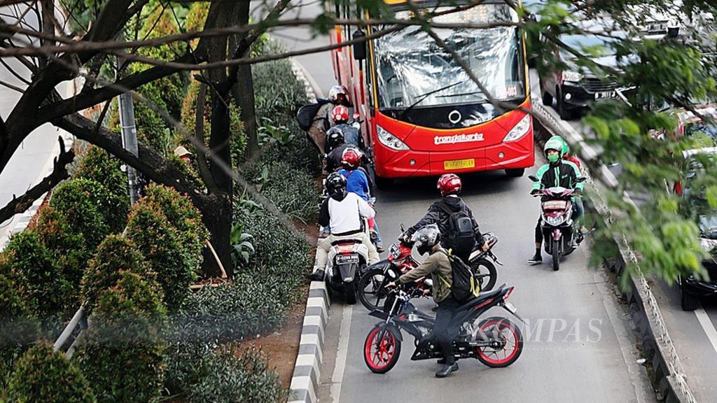 Pengendara sepeda motor yang melintasi jalur bus Transjakarta berputar balik untuk menghindari razia sterilisasi jalur tersebut di Jalan Kramat Raya, Jakarta Pusat, Rabu (7/6/2017). Tindakan<i> illegal contraflow</i> ini sangat membahayakan pesepeda motor yang tidak taat aturan dan pengguna jalan lain.