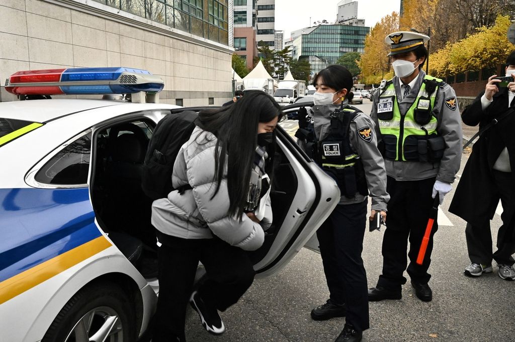 Seorang siswa tiba di tempat ujian dengan pengawalan polisi saat akan mengikuti ujian masuk perguruan tinggi di Seoul, Korea Selatan, yang dikenal dengan <i>suneung</i>, Kamis (18/11/2021). 
