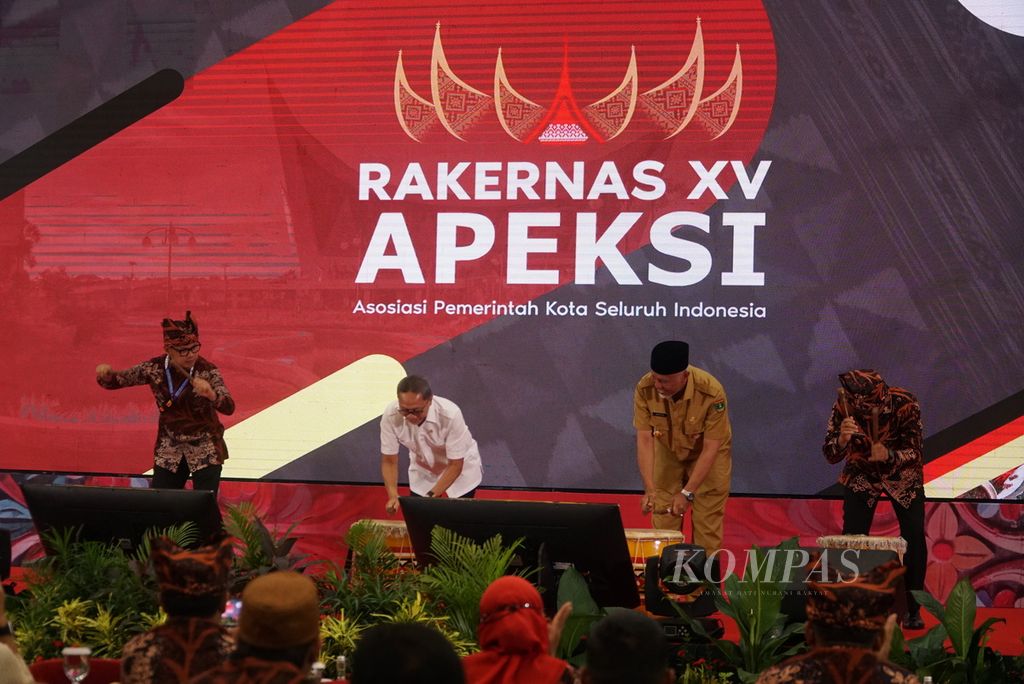 Ketua Dewan Pengurus Apeksi sekaligus Wali Kota Bogor Bima Arya Sugiarto (kiri), Menteri Perdagangan Zulkifli Hasan (dua dari kiri), Gubernur Sumatera Barat Mahyeldi (dua dari kanan), dan Wali Kota Padang Hendri Septa (kanan) memukul tambua tansa dalam acara pembukaan Rakernas Apeksi XV di Kota Padang, Sumatera Barat, Senin (8/8/2022). Rakernas Apeksi ini digelar pada 7-10 Agustus 2022 dan diikuti oleh 95 dari 98 pemerintah kota di Indonesia.