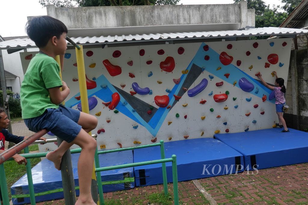 Eliezer Immanuel Hamonangan Widianto mengamati kakaknya, El Shaddai Uli Basa Widianto, berlatih di dinding panjat tebing di Neo Permata Bintaro, Tangerang Selatan, Banten, Jumat (18/11/2022). 