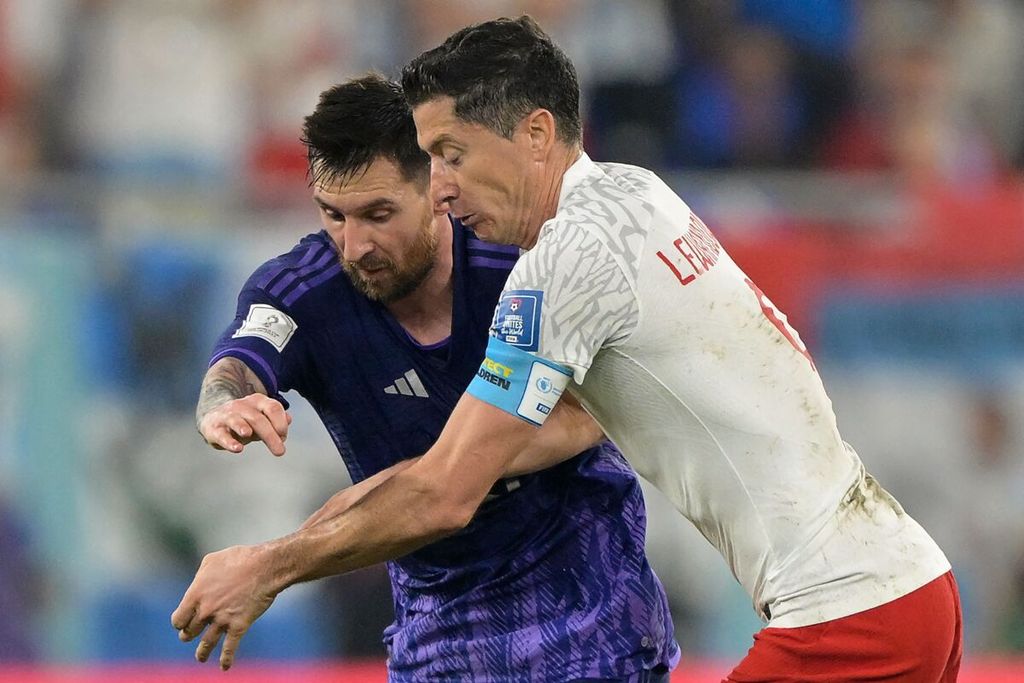 Penyerang Argentina Lionel Messi dan penyerang Polandia Robert Lewandowski berebut bola saat laga Grup C Piala Dunia 2022 antara Polandia dan Argentina di Stadion 974, Doha, Qatar, Kamis (1/12/2022) dini hari WIB. 