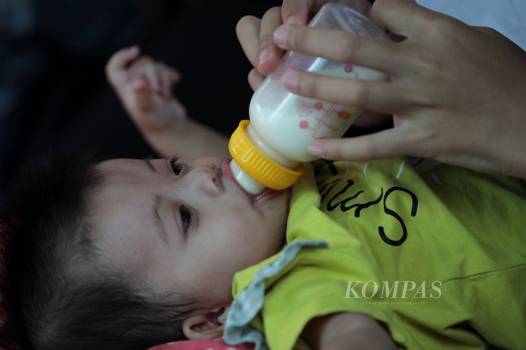 Anak balita diberi minum susu oleh ibunya saat menunggu kedatangan Wakil Presiden Maruf Amin untuk meninjau pencegahan dan penanganan <i>stunting</i> di Puskesmas Mranggen III, Kecamatan Mranggen, Demak, Jawa Tengah, Selasa (4/4/2023). 