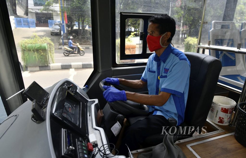 Pengemudi mengenakan masker wajah dan sarung tangan saat mengoperasikan Bus Rapid Trans (BRT) Tangerang Ayo (Tayo) di kawasan Cikokol, Kota Tangerang, Sabtu (18/4/2020). 