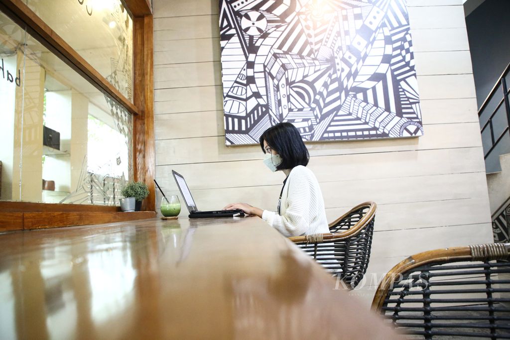 Jeany Simatupang, mahasisiwi Universitas Diponegoro, tengah menyelesaikan tugas kuliah dan pekerjaan paruh waktunya dari sebuah kedai kopi di bilangan Bintaro, Pondok Aren, Tangerang Selatan, Banten, Jumat (12/11/2021). 